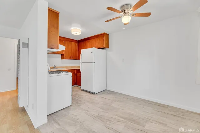a view of a kitchen with wooden floor and a ceiling fan
