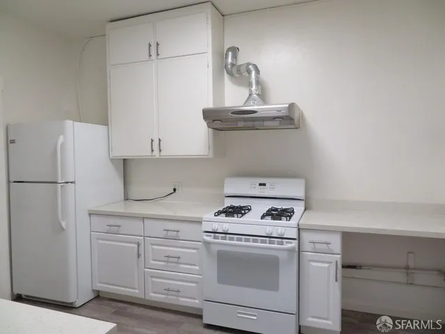 a kitchen with white cabinets and white appliances