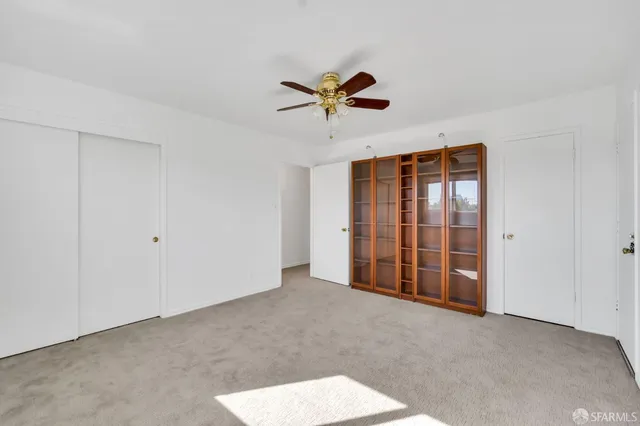 a view of a livingroom with a ceiling fan and window