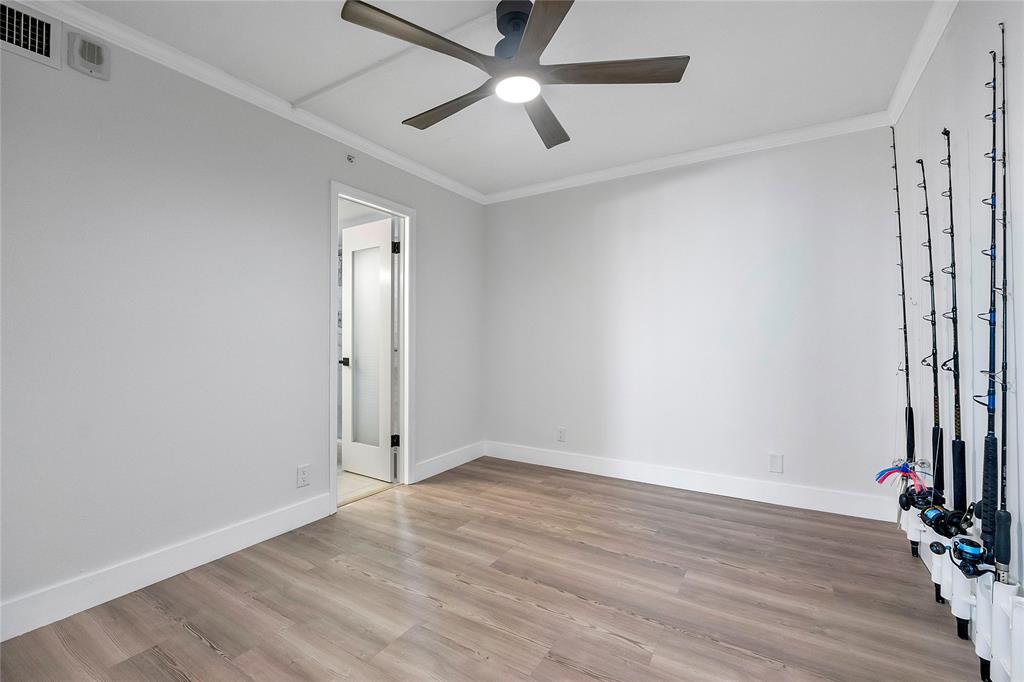 1505 North Riverside Drive, Unit 1003 Pompano Beach, FL 33062 - Photo 12 of 33 an empty room with wooden floor and a ceiling fan