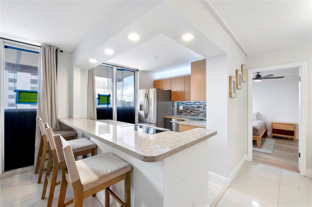 1505 North Riverside Drive, Unit 1003 Pompano Beach, FL 33062 - Photo 3 of 33 a kitchen with granite countertop kitchen island stainless steel appliances a sink and a refrigerator