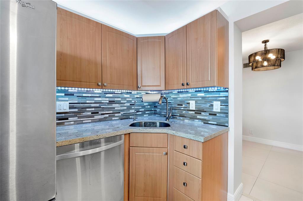 1505 North Riverside Drive, Unit 1003 Pompano Beach, FL 33062 - Photo 4 of 33 a kitchen with granite countertop cabinets and white appliances