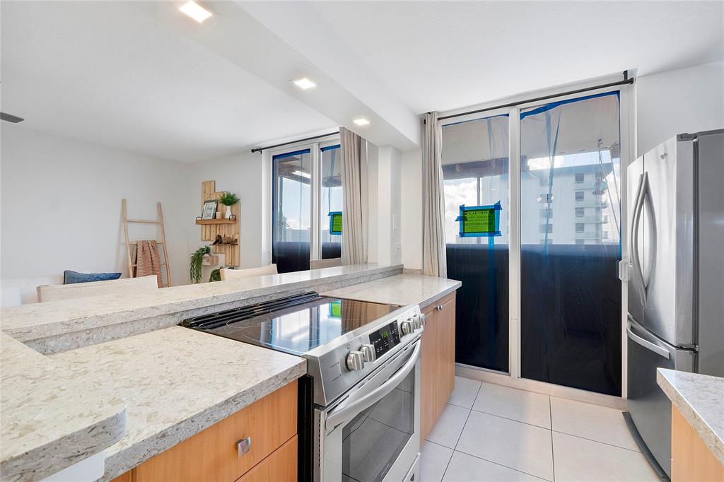 1505 North Riverside Drive, Unit 1003 Pompano Beach, FL 33062 - Photo 5 of 33 a kitchen with a sink a counter top space and stainless steel appliances