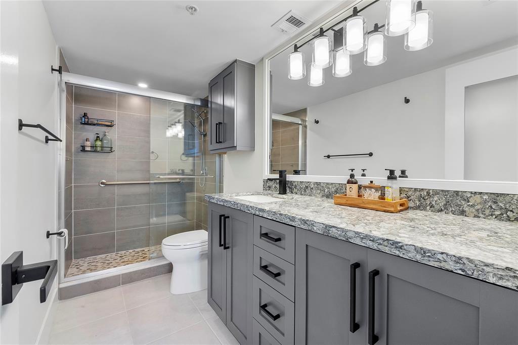 1505 North Riverside Drive, Unit 1003 Pompano Beach, FL 33062 - Photo 8 of 33 a bathroom with a granite countertop sink a toilet a mirror and shower