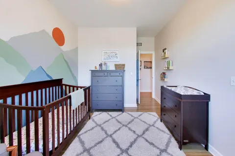 a bedroom with a bed and wooden floor