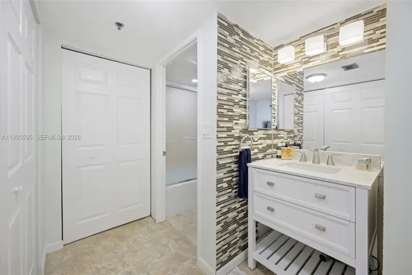 a bathroom with a sink a mirror and a shower