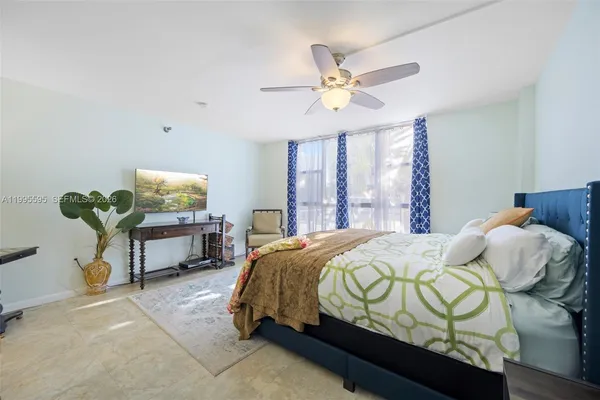 a bedroom with a bed table chair and a window