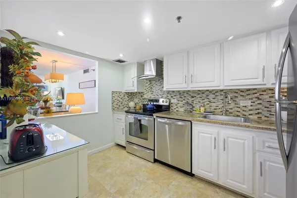 a kitchen with granite countertop white cabinets and white appliances