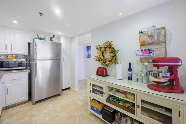 a kitchen with a refrigerator and a stove top oven