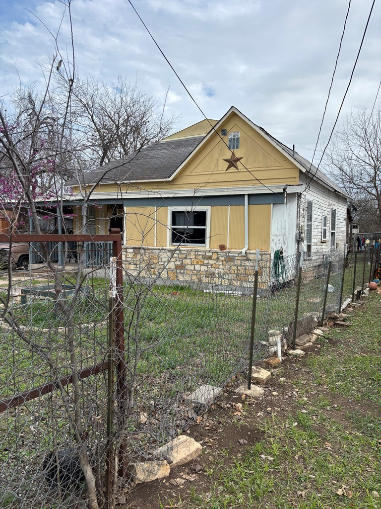 725 Swigert Street Kerrville, TX 78028 - Photo 2 of 17 a view of a yard in front of a house with large windows