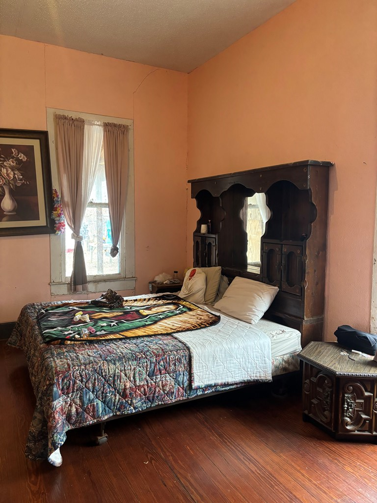 725 Swigert Street Kerrville, TX 78028 - Photo 7 of 17 a bedroom with a bed and wooden floor