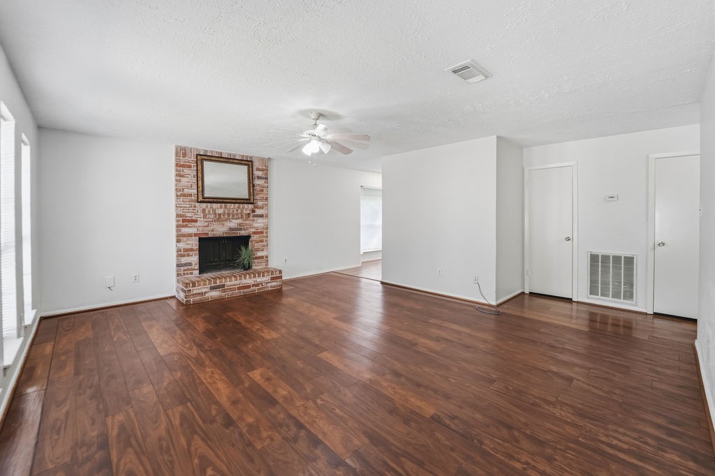 4542 Algernon Drive Spring, TX 77373 - Photo 10 of 19 an empty room with wooden floor fireplace and windows