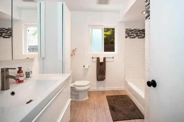a bathroom with a sink a toilet and shower