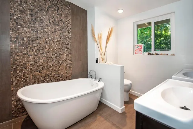 a white bath tub sitting next to a white toilet