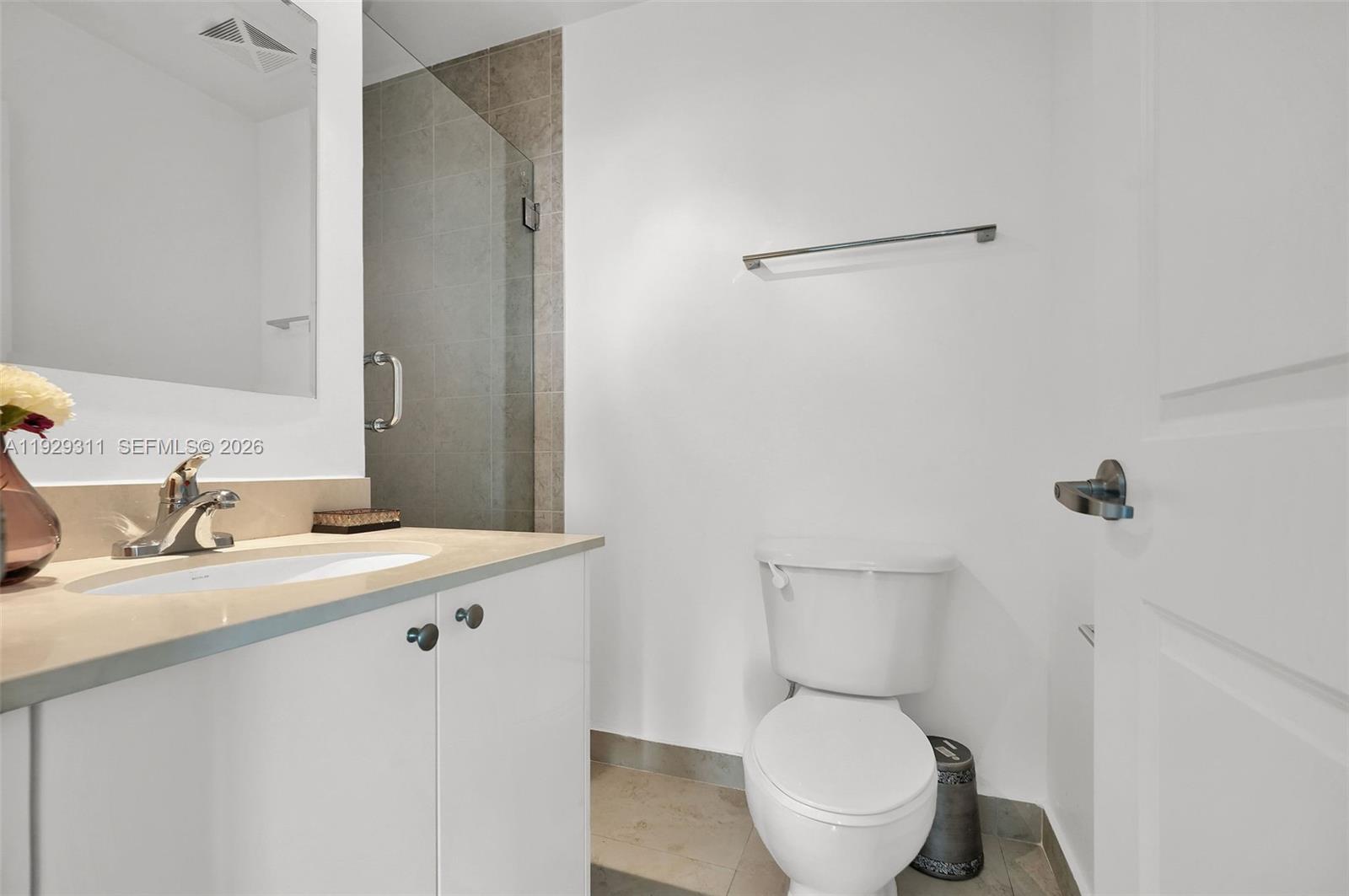 60 Southwest 13th Street, Unit 4607 Miami, FL 33130 - Photo 19 of 39 a bathroom with a toilet a sink and mirror