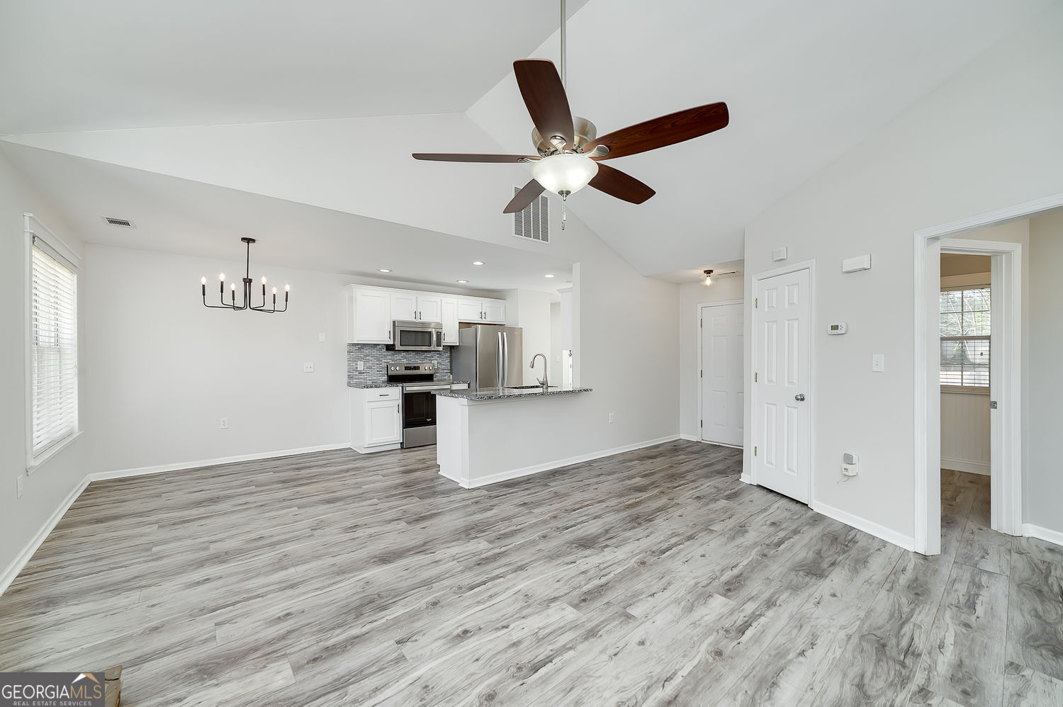 524 Leguin Mill Road Locust Grove, GA 30248 - Photo 19 of 44 a view of kitchen and empty room with wooden floor