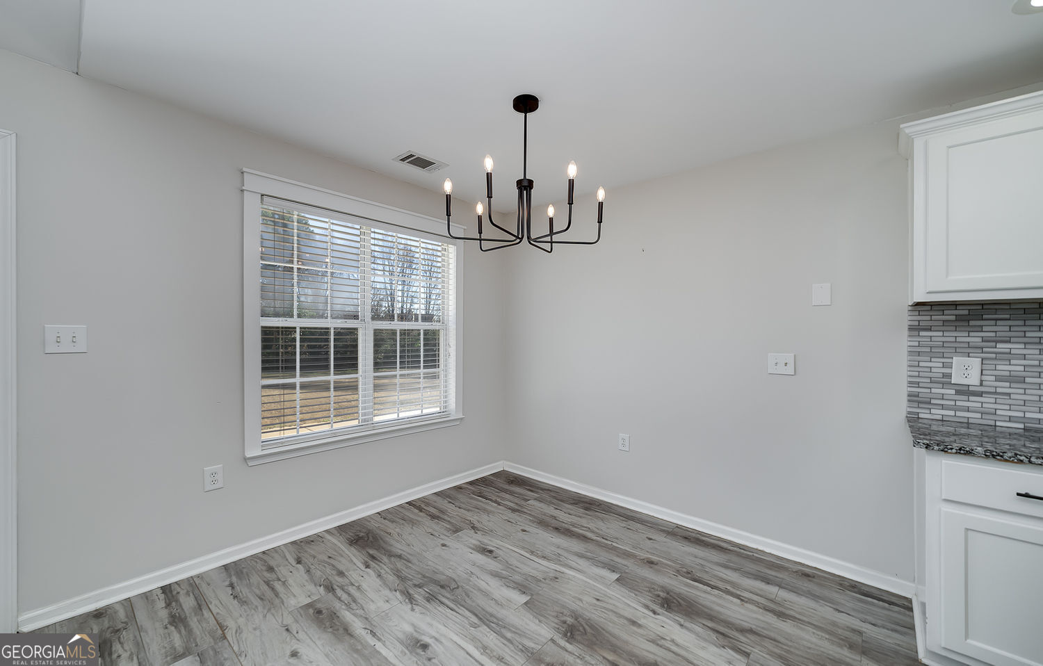 524 Leguin Mill Road Locust Grove, GA 30248 - Photo 21 of 44 a view of empty room with wooden floor and fan