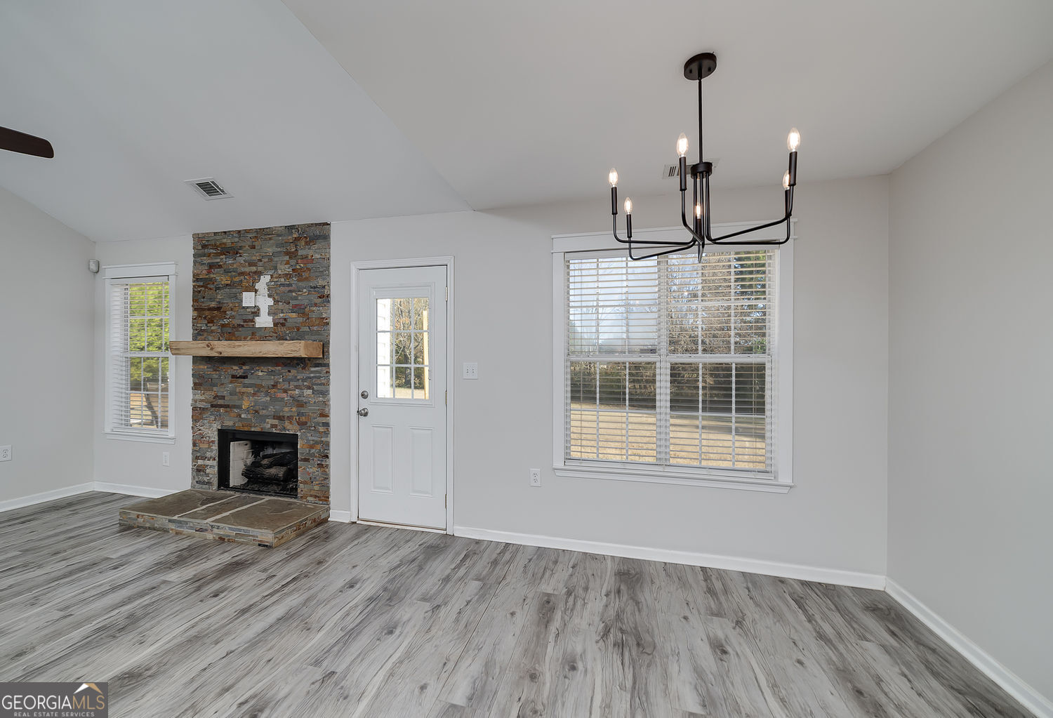 524 Leguin Mill Road Locust Grove, GA 30248 - Photo 22 of 44 an empty room with wooden floor fireplace and windows