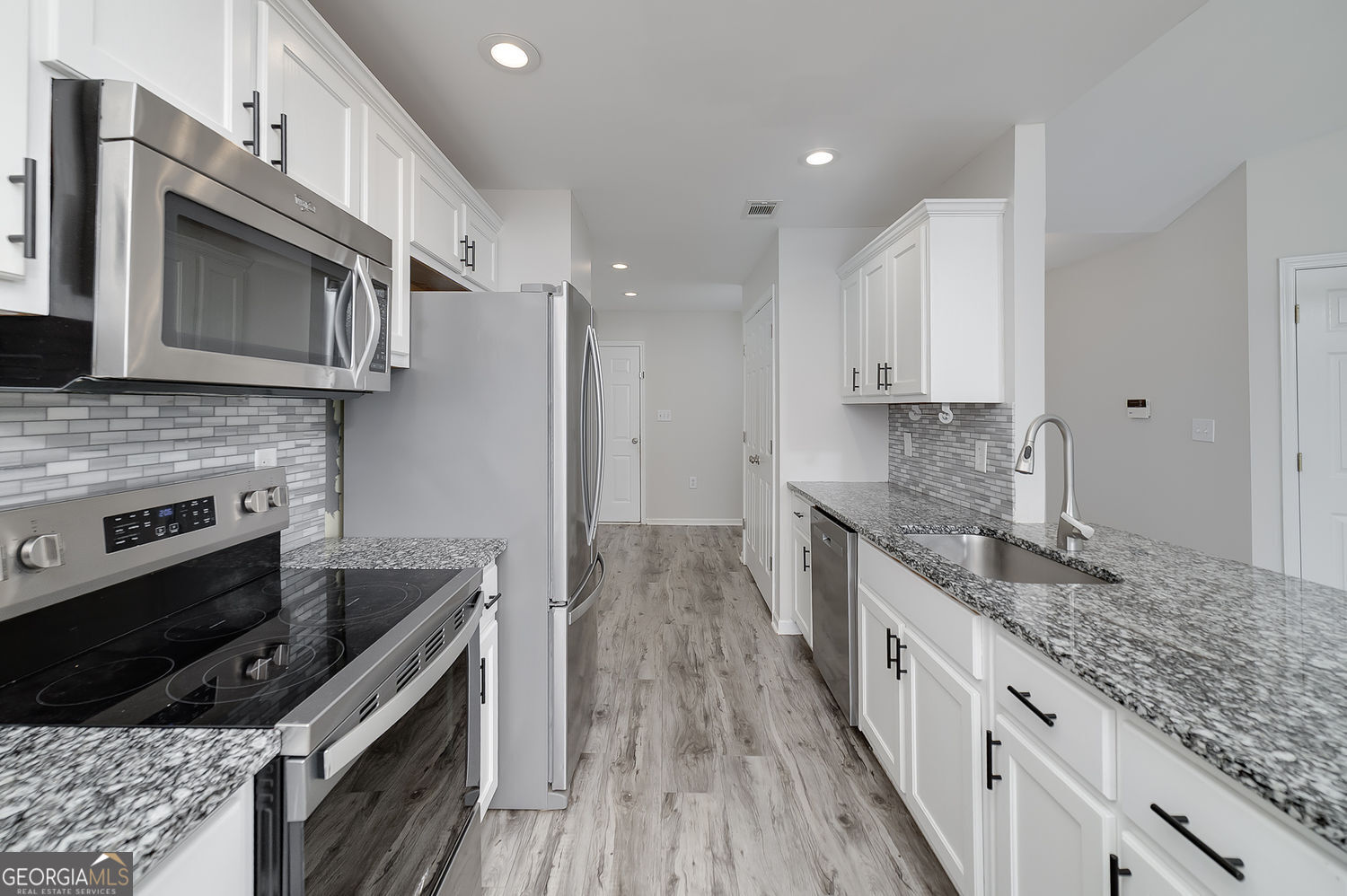 524 Leguin Mill Road Locust Grove, GA 30248 - Photo 26 of 44 a kitchen with stainless steel appliances granite countertop a stove a sink and a microwave