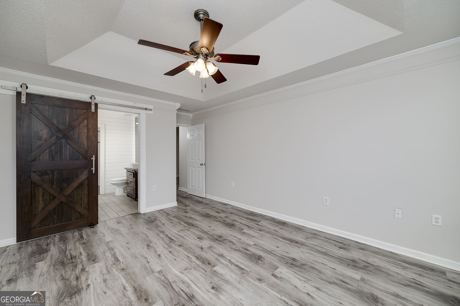 524 Leguin Mill Road Locust Grove, GA 30248 - Photo 30 of 44 a view of an empty room with wooden floor and a ceiling fan