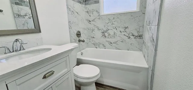 a bathroom with a sink a toilet and bathtub