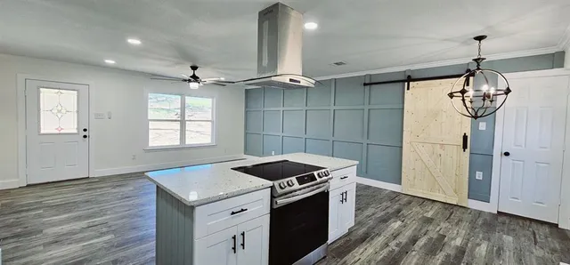 a kitchen that has a stove and a wooden floor