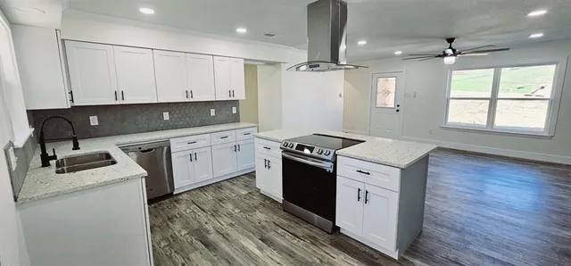 a kitchen that has a sink stainless steel appliances a counter space and a window