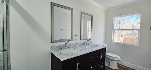a bathroom with a granite countertop sink toilet and mirror