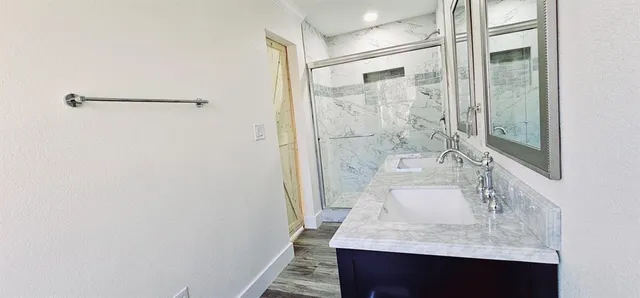 a bathroom with a granite countertop shower sink and mirror