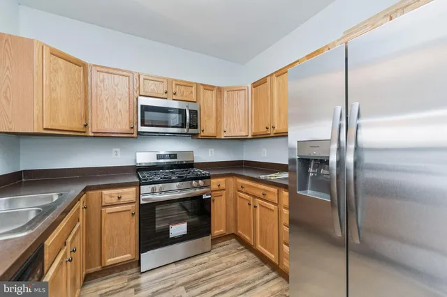 a kitchen with stainless steel appliances granite countertop a stove a sink and a refrigerator