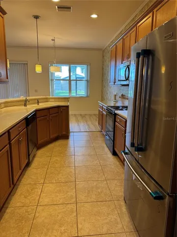 a large kitchen with stainless steel appliances a sink a counter space and a window