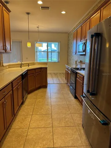 a large kitchen with kitchen island granite countertop a stove a sink dishwasher and a refrigerator