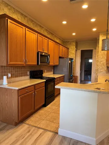 a kitchen with stainless steel appliances granite countertop a stove a sink and a refrigerator