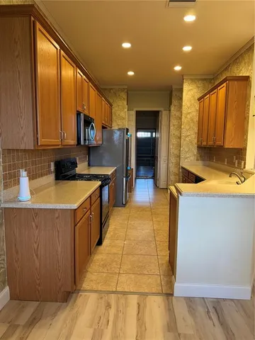 a kitchen with a sink a counter top space appliances and cabinets