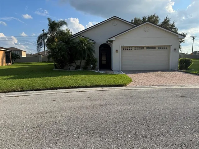 a front view of a house with a yard and garage