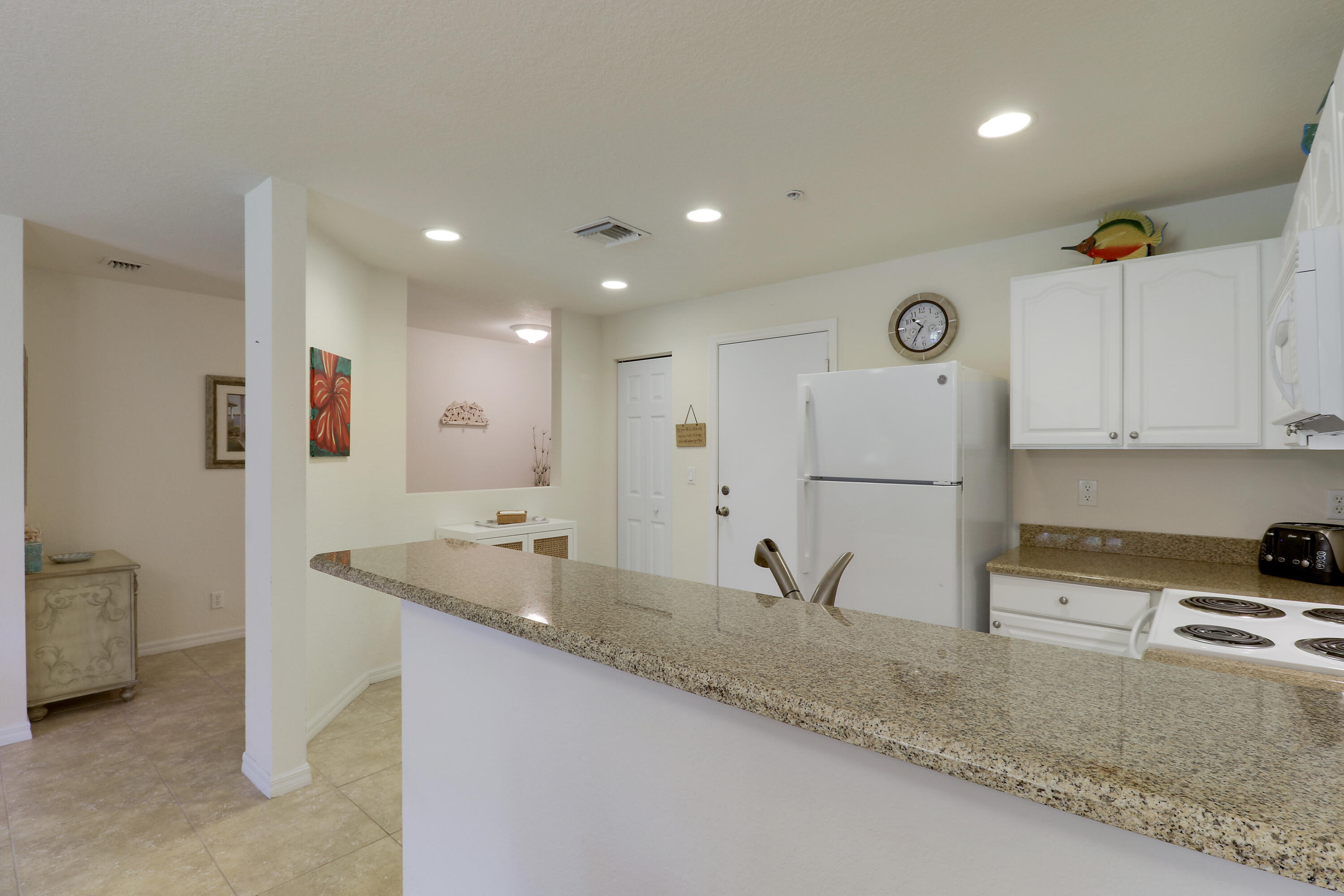 5410 Southeast Mitchell Lane Stuart, FL 34997 - Photo 9 of 24 a kitchen with stainless steel appliances granite countertop a sink and a refrigerator