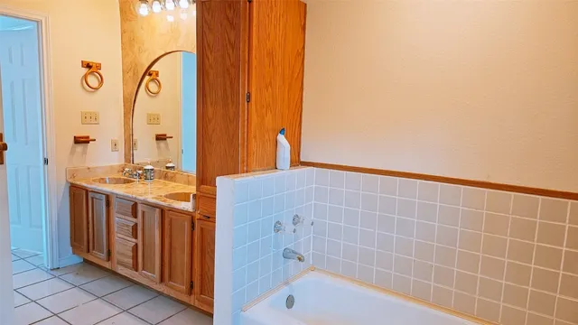 a bathroom with a tub sink and mirror