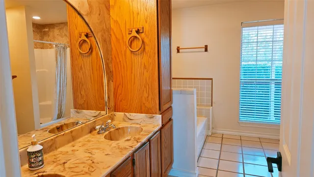 a bathroom with a granite countertop sink and a shower