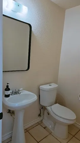 a bathroom with a toilet a sink and mirror