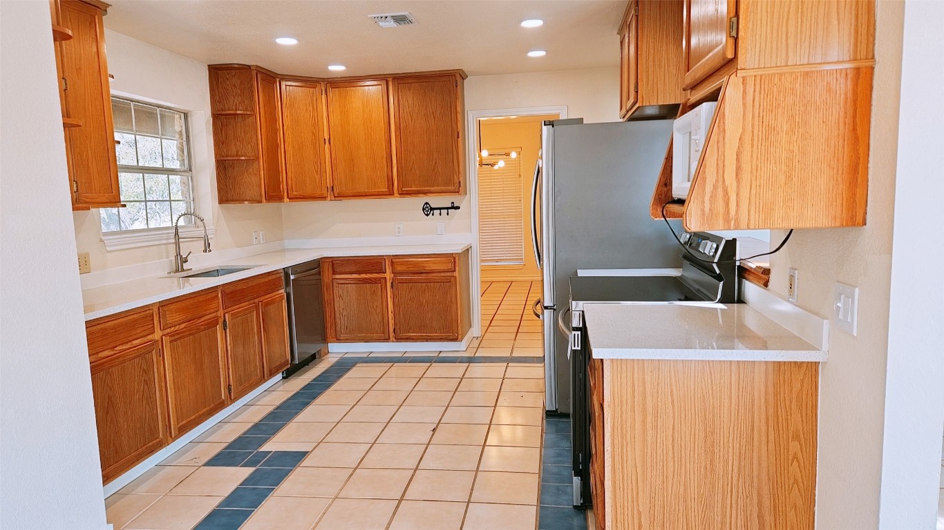 105 Meadow Drive Georgetown, TX 78633 - Photo 7 of 24 a kitchen with stainless steel appliances a sink and a refrigerator