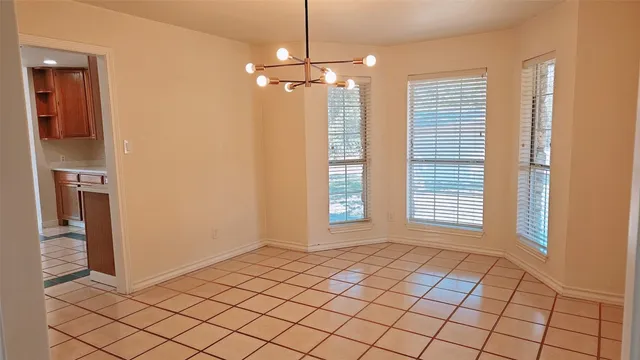 a view of an empty room with window and cabinet area