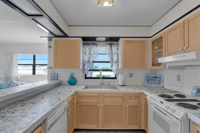a kitchen with granite countertop a sink stainless steel appliances and cabinets