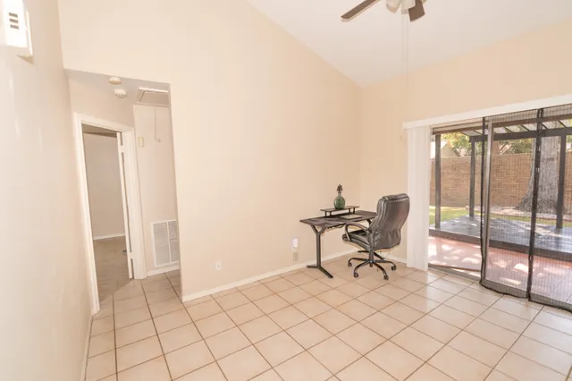 a view of a workspace with furniture and a window