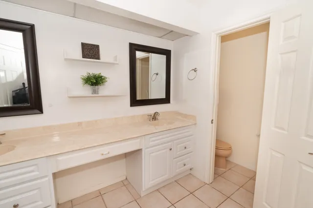a spacious bathroom with a granite countertop sink a mirror and shower