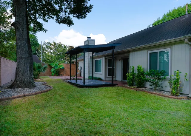 a view of a patio with table and chairs under an umbrella