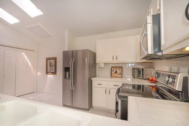 a kitchen with stainless steel appliances a refrigerator stove and microwave