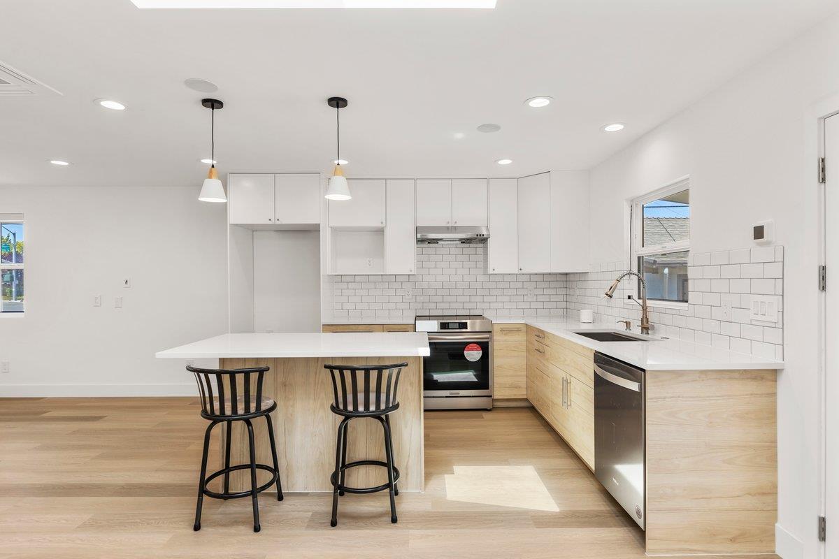 9930 Calvine Road Sacramento, CA 95829 - Photo 77 of 97 a kitchen with stainless steel appliances granite countertop a kitchen island a stove a sink cabinets and a dining table with the kitchen island
