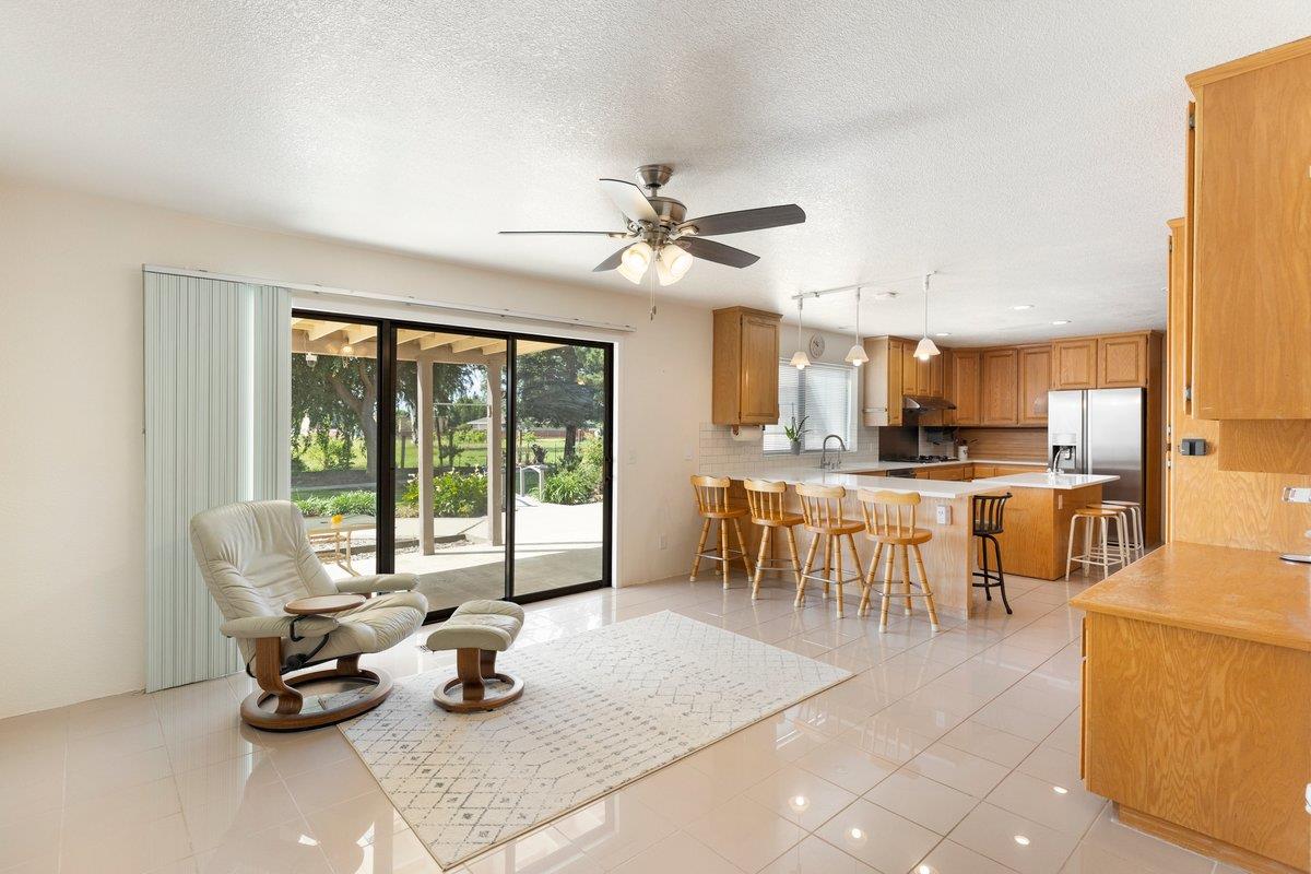 9930 Calvine Road Sacramento, CA 95829 - Photo 10 of 97 a dining room with furniture a floor to ceiling window and a kitchen view