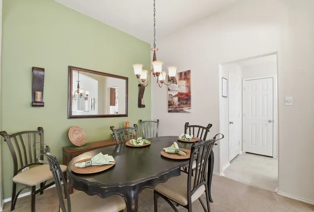 a living room with furniture a chandelier and a view of kitchen