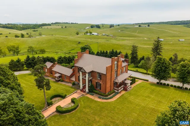 an aerial view of a house with pool garden and outdoor seating